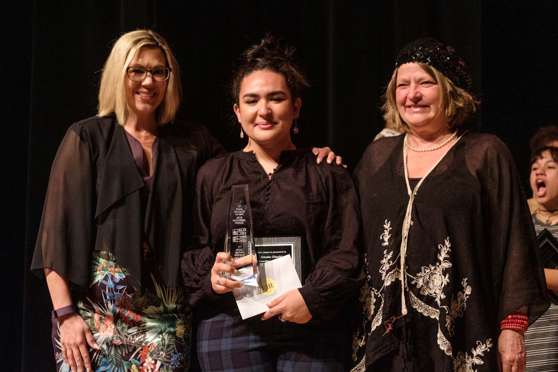 La ministre Squires et la poète officielle de Winnipeg, Di Brandt, remettent des trophées aux lauréat et lauréates des prix. Ici, Ghada Charki, reçoit le premier prix de la section bilingue.