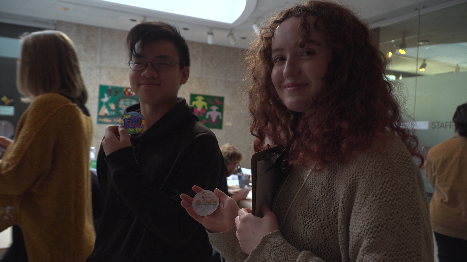 William Zhang and Sophia Wilcott show off the poetry buttons they made.