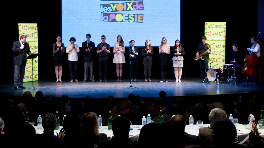 The nine finalists joined Albert Schultz on stage before the competition. (L. to r.) Liana Cusmano, Alexander Gagliano, Jeff Hunt, Josh Cape, Mary Jane Egan, Sidney Gilchrist, Sadie Anne Hirschfield, Eve Mangin, and Daniela Galdamez. 